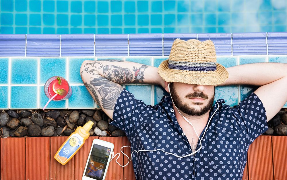 Caucasian man sleep sunbath and listening music beside the pool