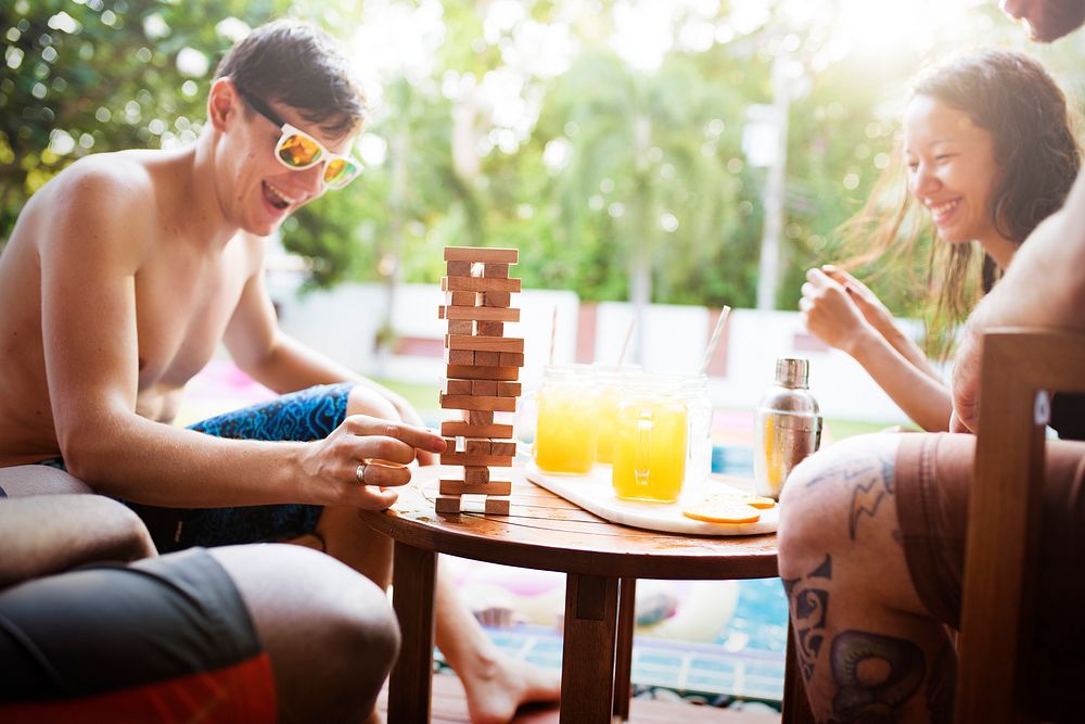Group of diverse playing wooden stack game together