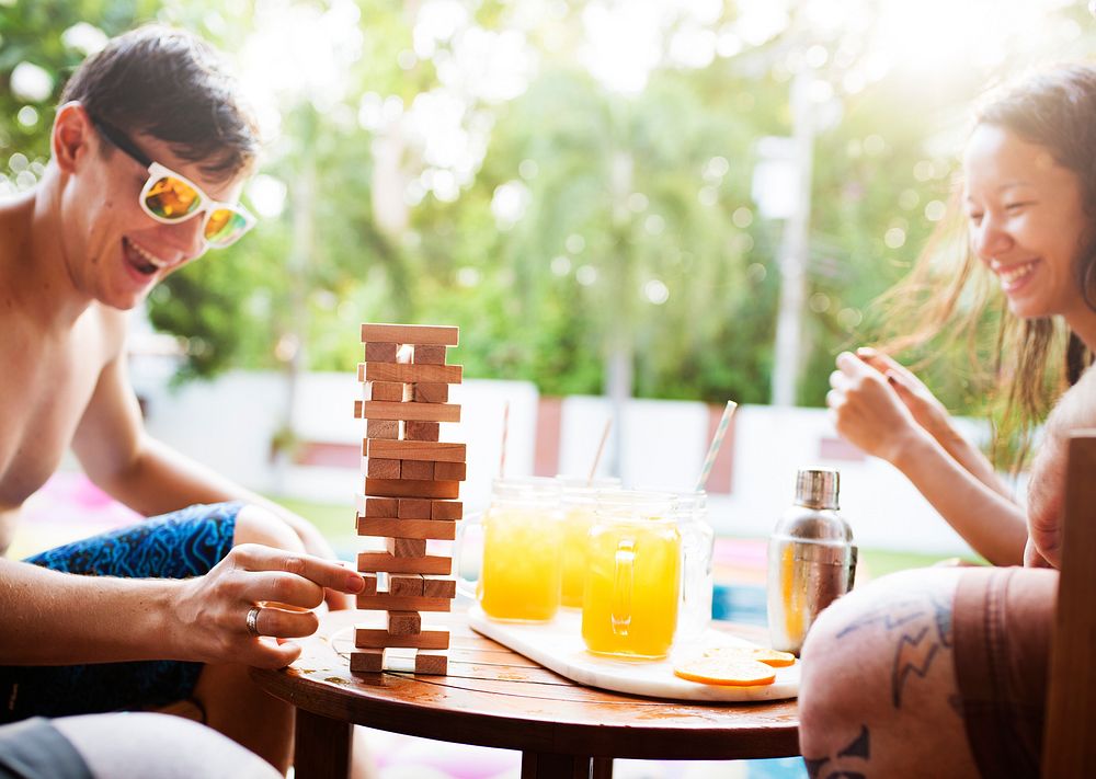 Group of diverse playing wooden stack game together