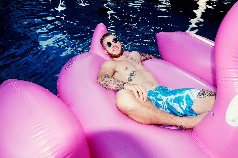 Caucasian man floating in the pool with inflatable