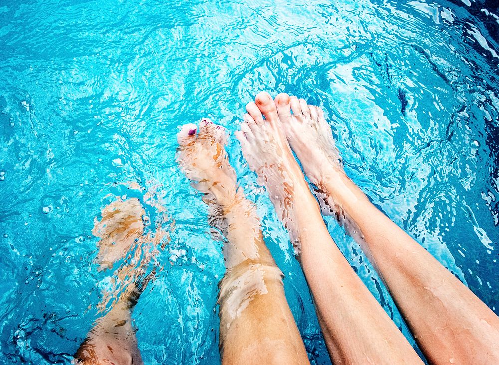 Pair of bare feet in swimming pool