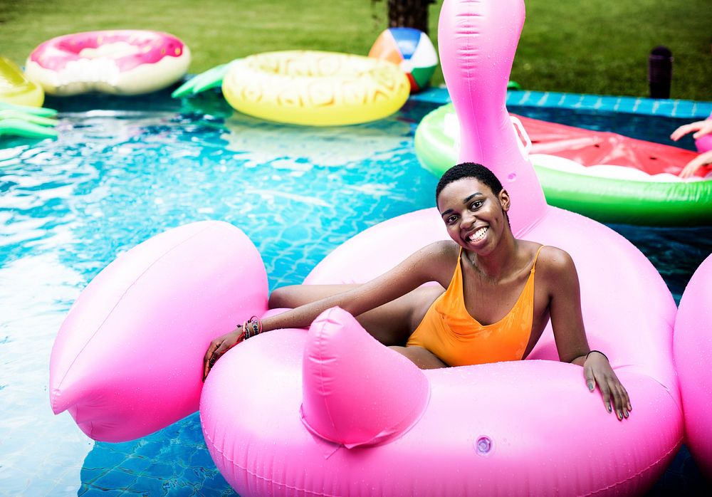 African descent girl floating on life ring in swimming pool