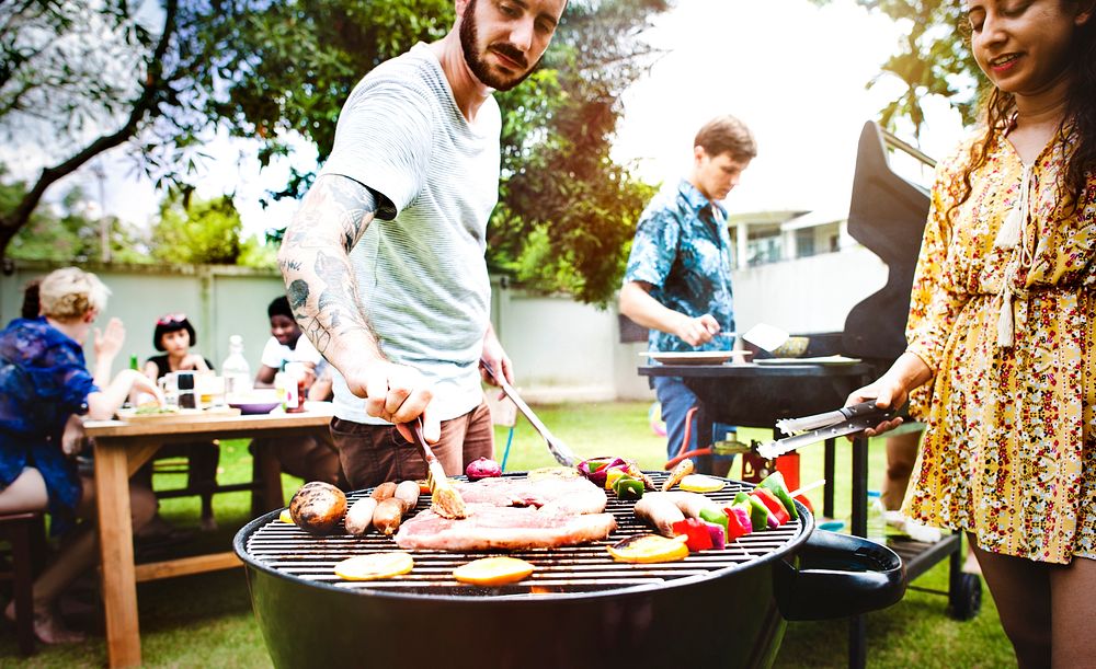 Group of diverse friends grilling barbecue outdoors