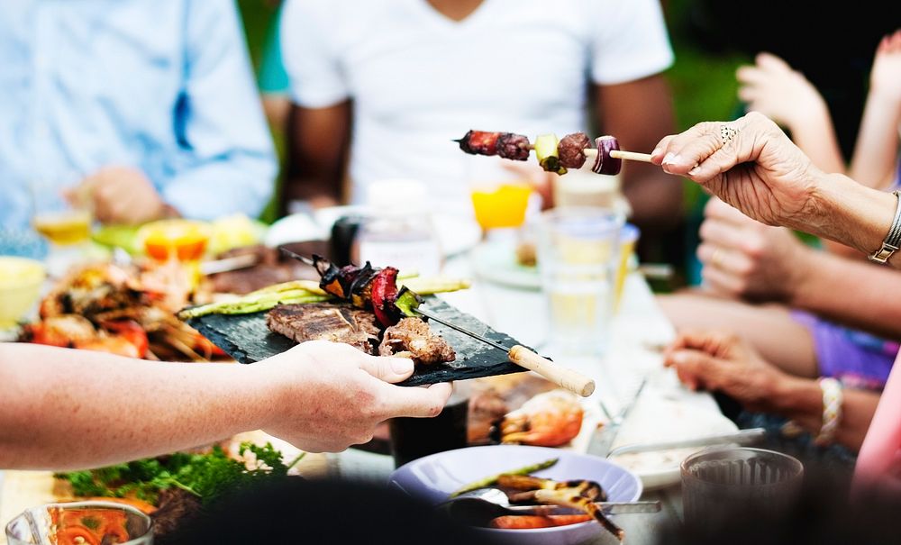 Group of people having BBQ party outdoors