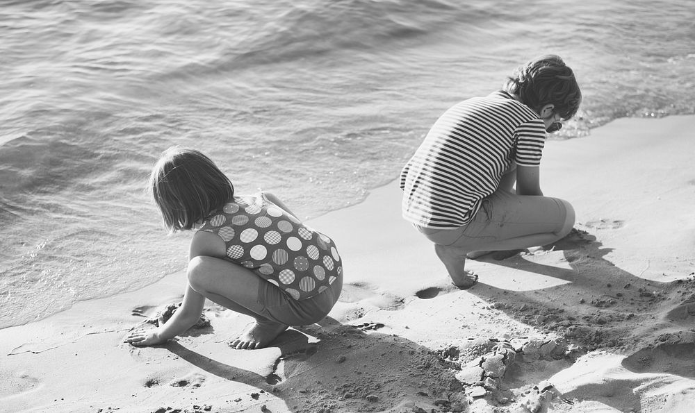 Little children playing sand by the seashore