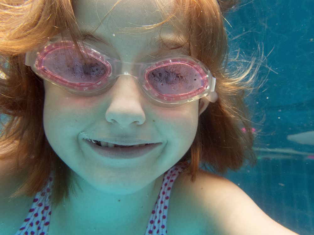 Girl with goggles diving in swimming pool
