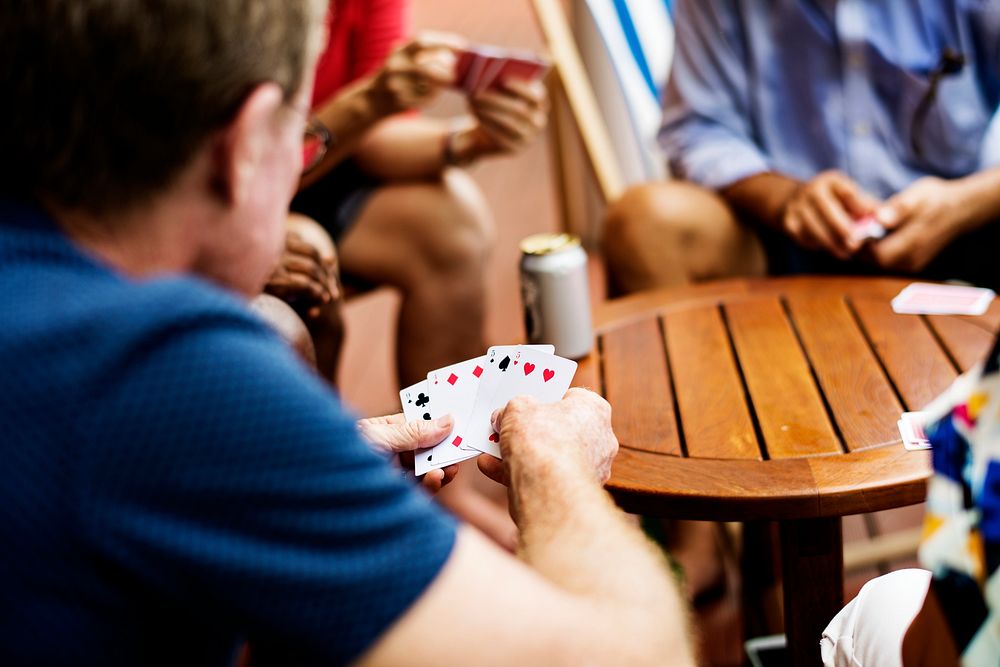 Rear view of man playing card game with friends