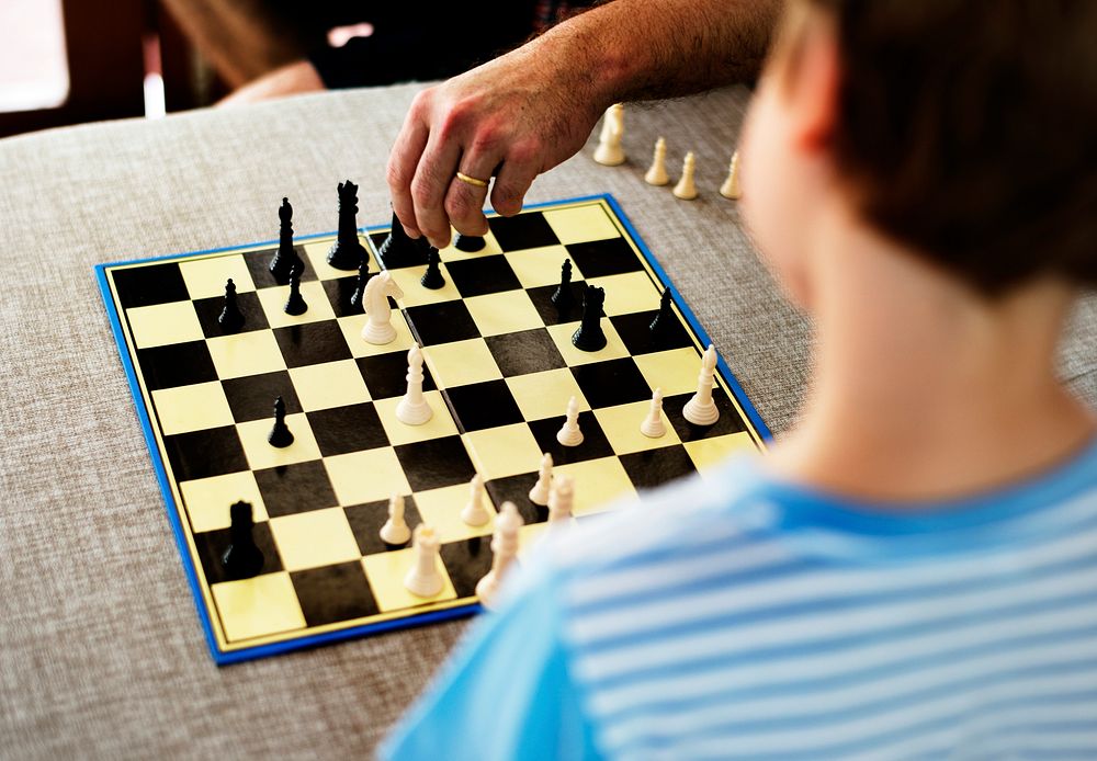 Rear view of young caucasian boy with chess boardgame