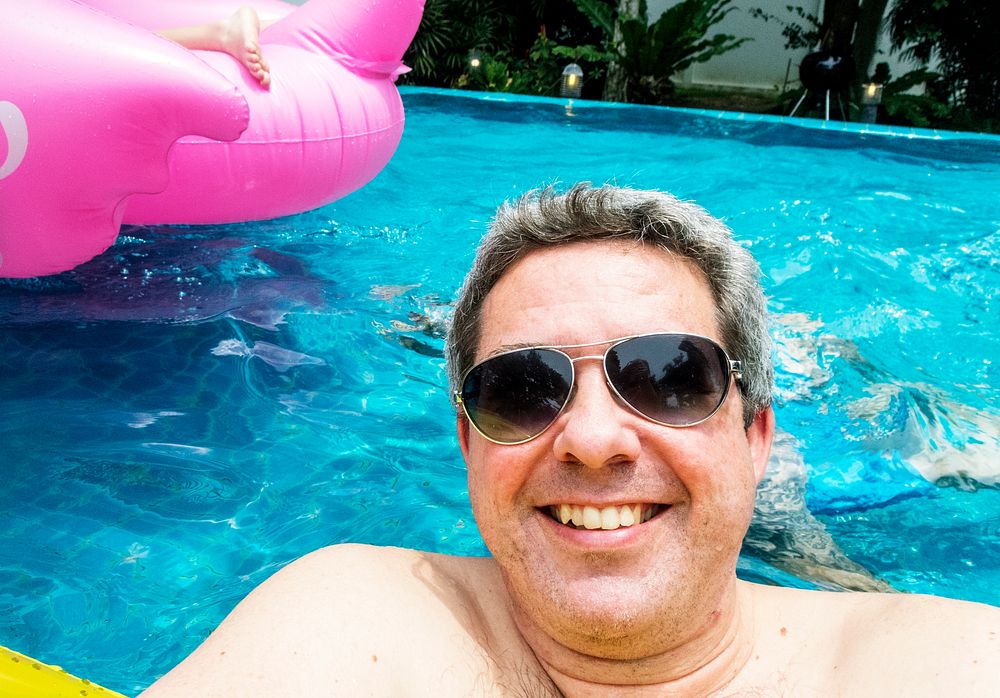 Man with sunglasses floating in a pool