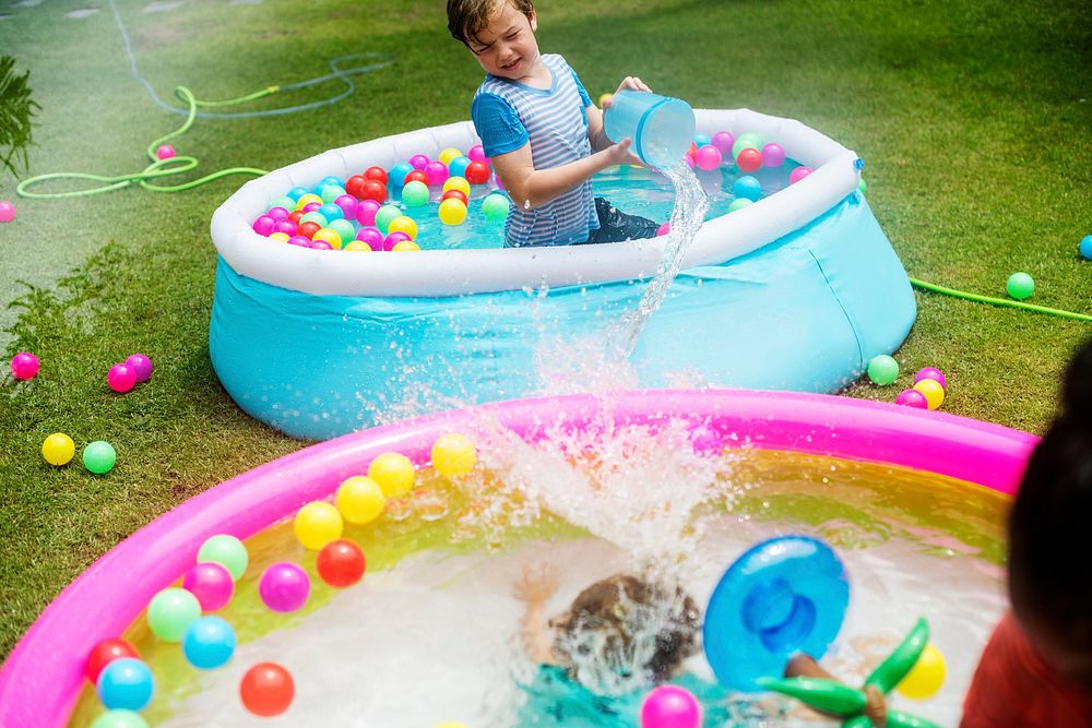 Young caucasian boy in inflatable pool enjoying water
