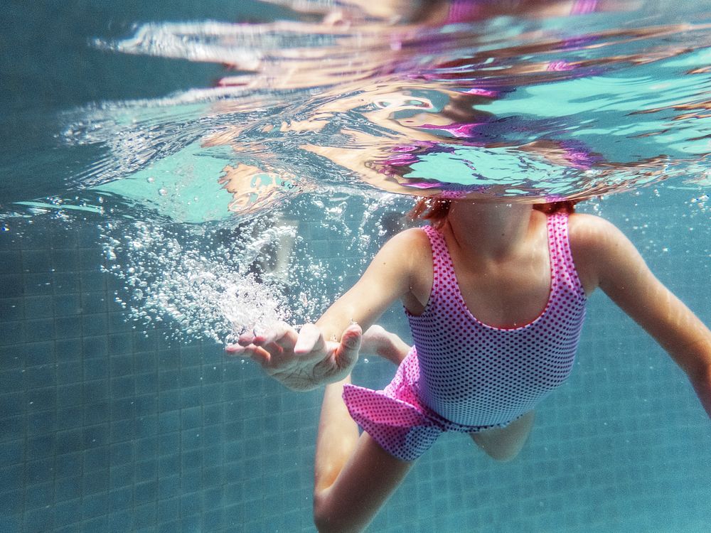 Closeup of caucasian girl underwater in the pool