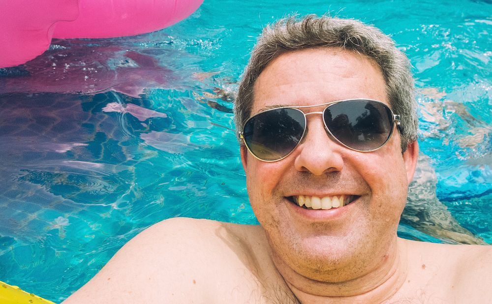 Man with sunglasses floating in a pool