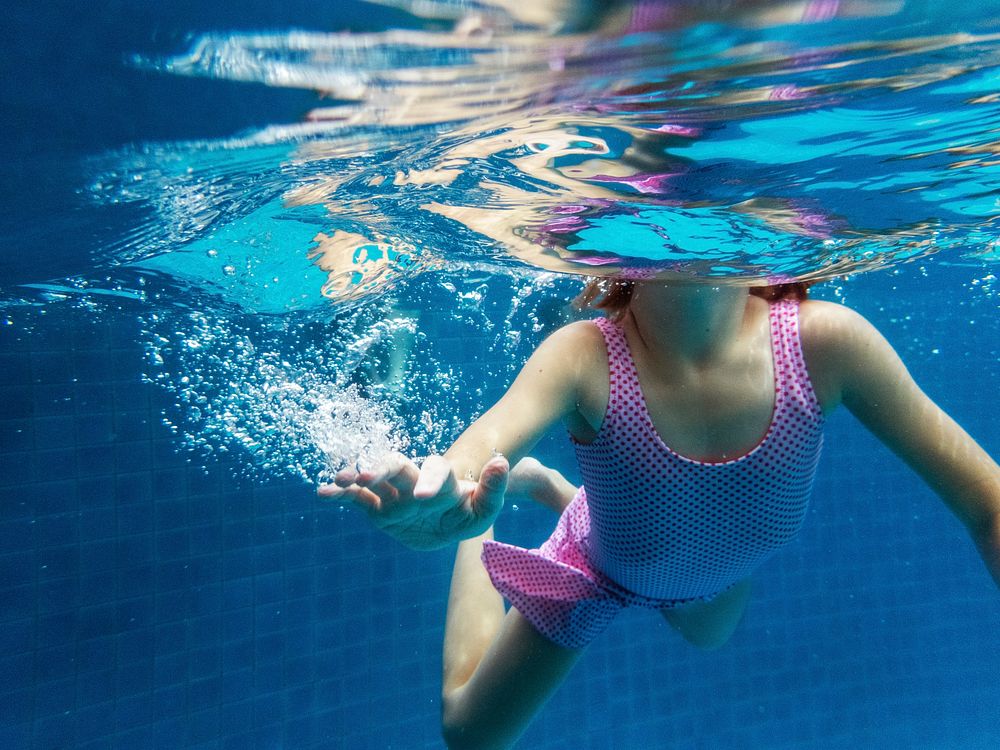 A girl swimmimg in a pool