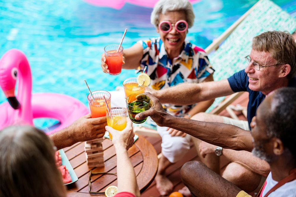 Group of diverse senior adult enjoying beverage by the pool together