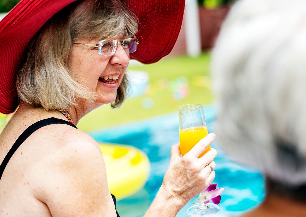 Closeup of senior caucasian woman with juice by the pool