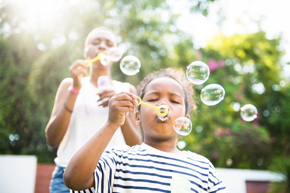African descent girl blowing bubbles outdoor