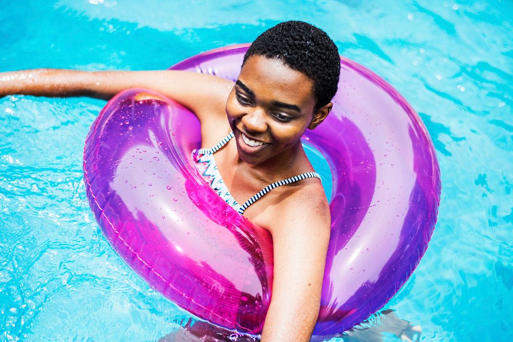 Closeup of black woman floating with tube in the pool