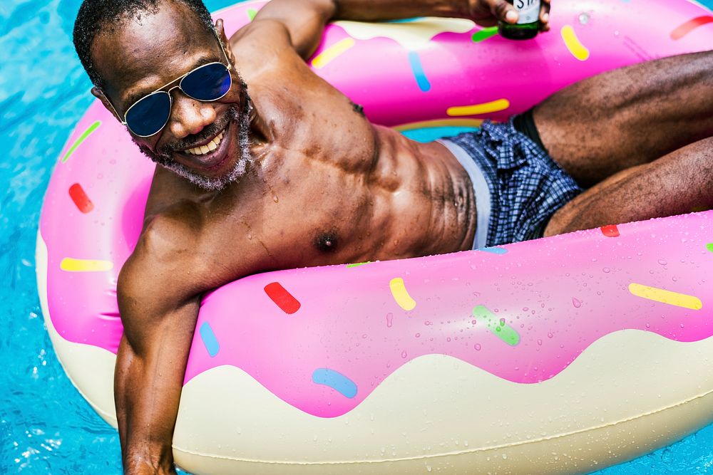 Closeup of senior african descent man floating in the pool with inflatabel tube
