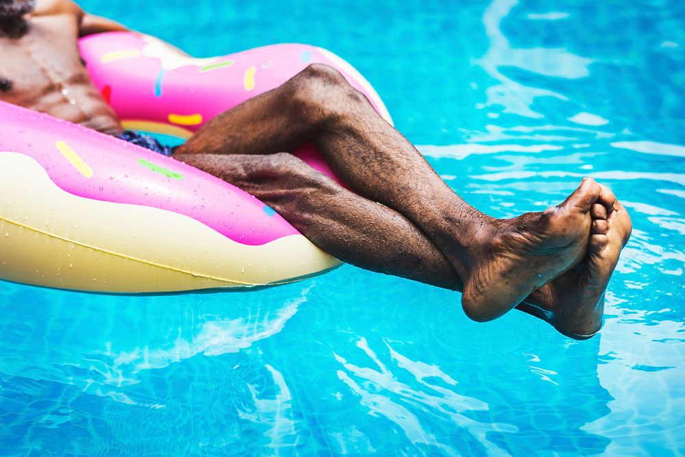 African descent man floating in a pool