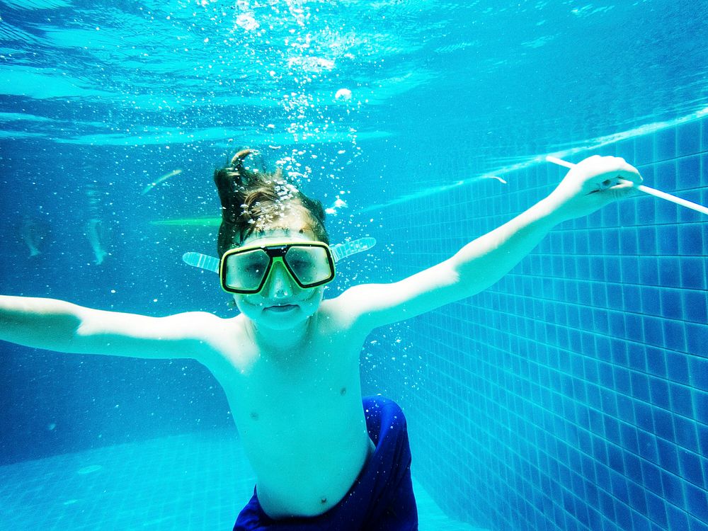 Closeup of caucasian boy underwater in the pool