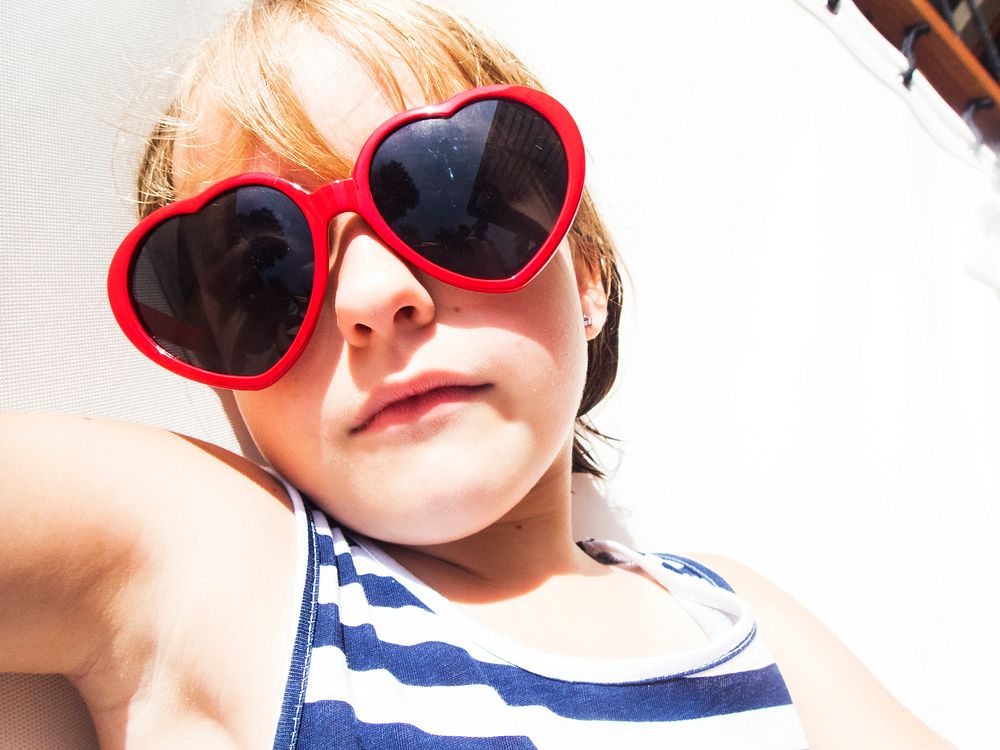 Closeup of young caucasian girl sunbathing with sunglassses