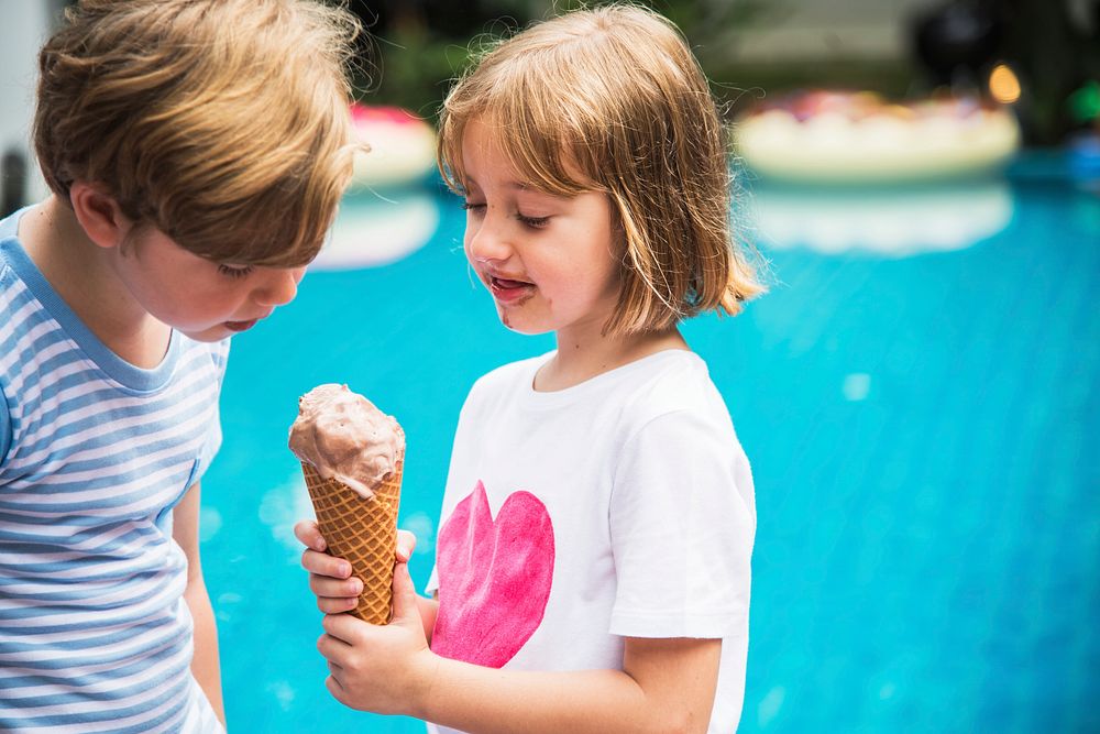 Closeup of young caucasian sibling sharing ice cream together