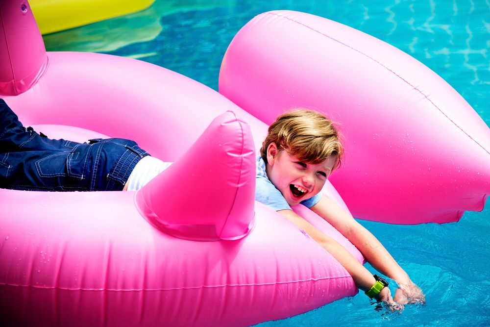 Caucasian boy floating in the pool with inflatable