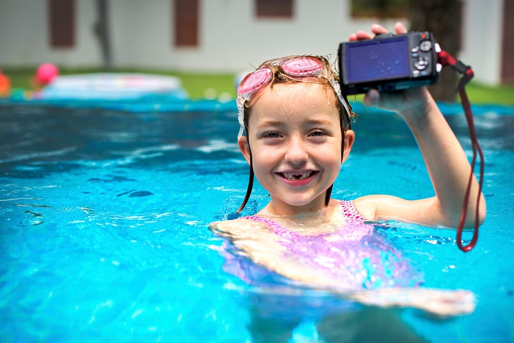 Girl with waterproof camera in a pool