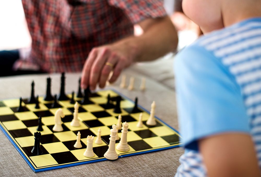 Family generation playing chess together