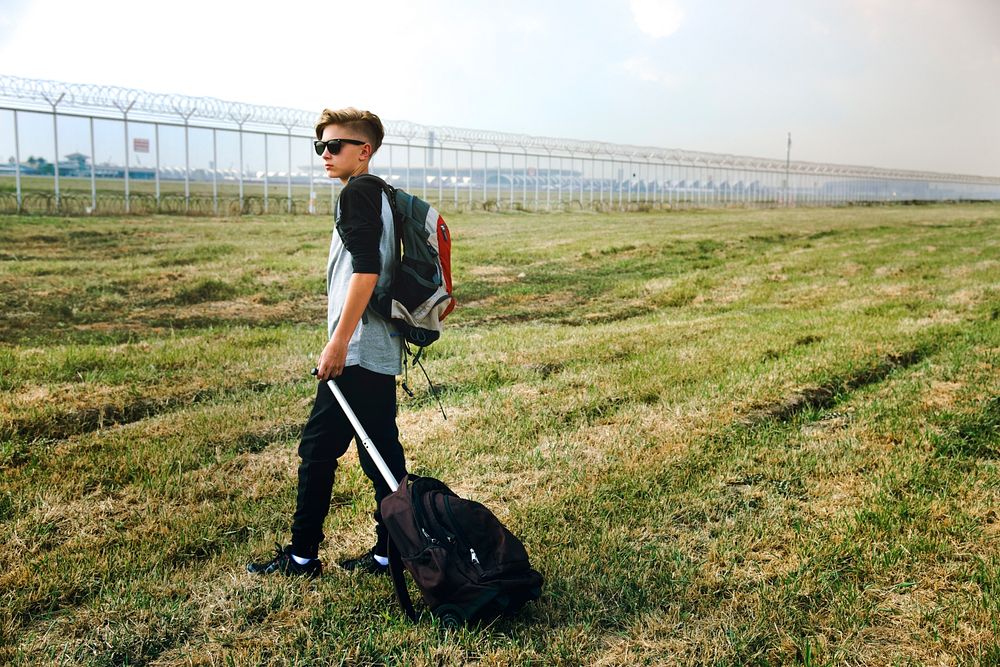 Young caucasian man travel with luggage outdoors