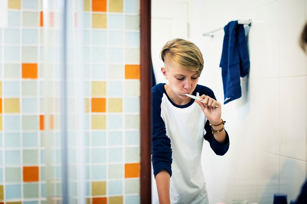 Young caucasian man brushing teeth in bathroom