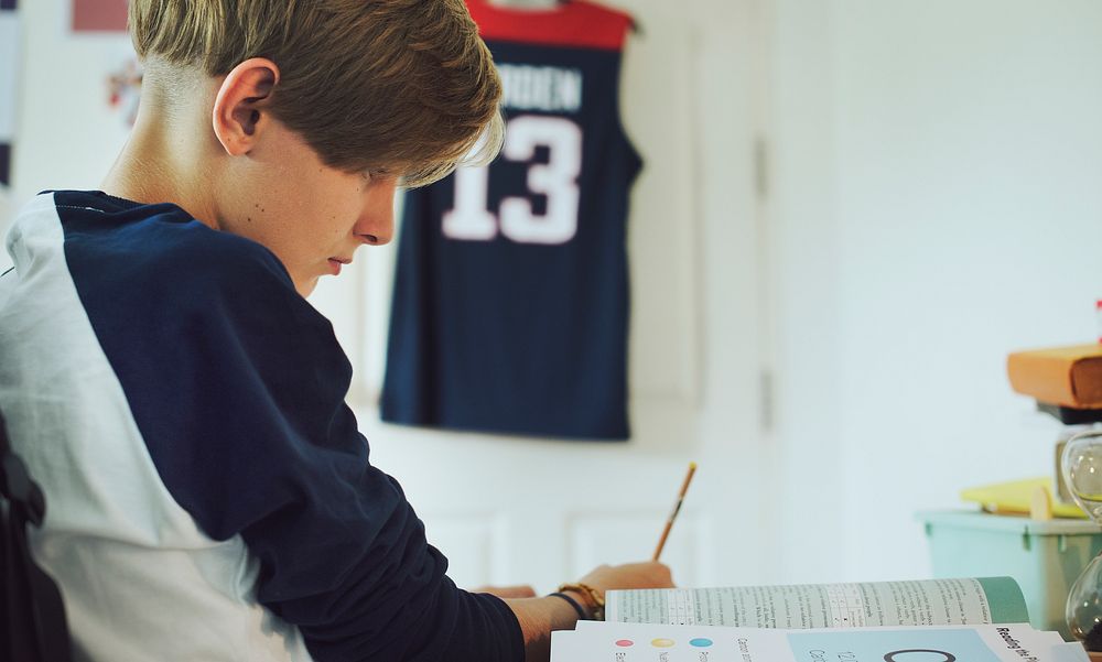 Young caucasian boy doing homework