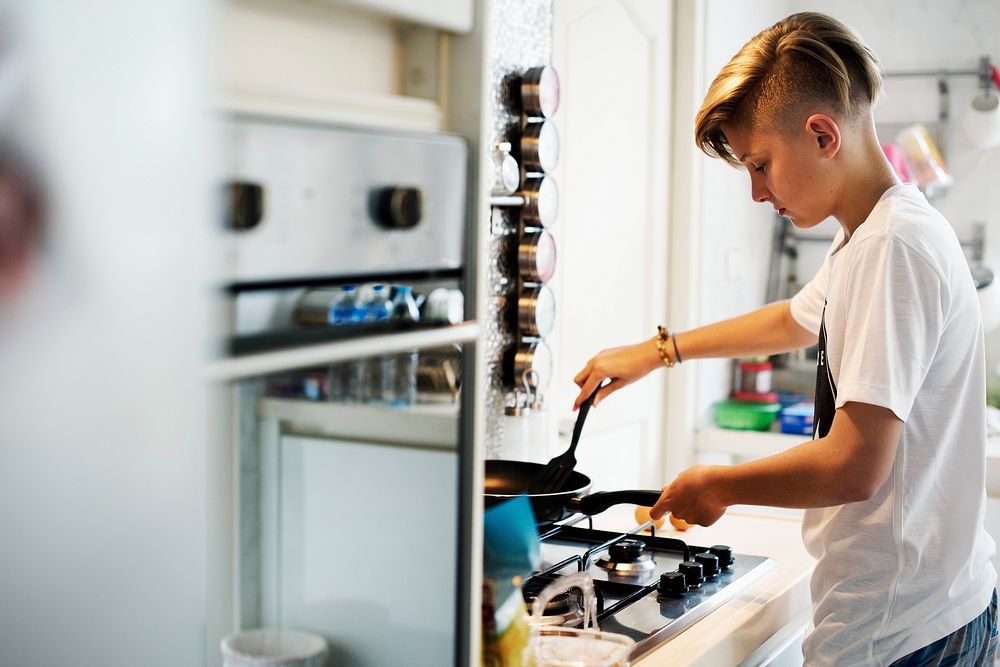 Young caucasian man cooking in the kitchen