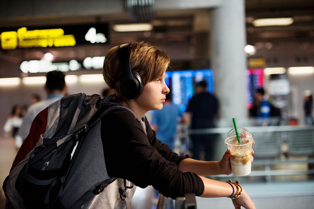 Young caucasian traveler holding drink beverage in the airport
