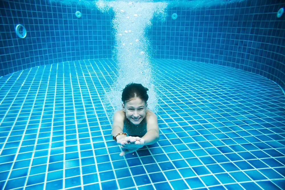 Teenage boy diving underwater of swimming pool