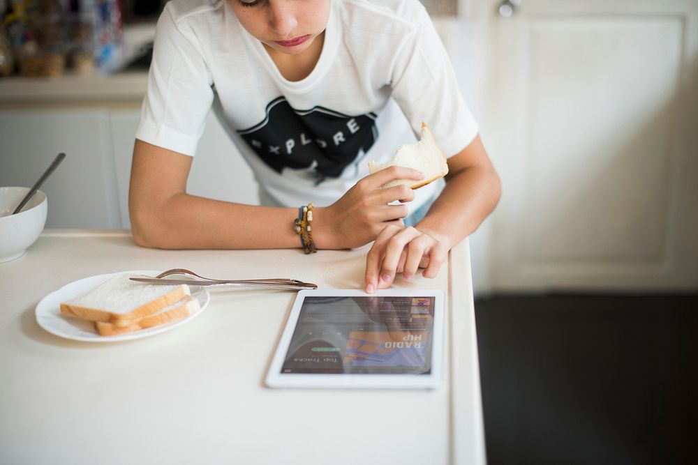Young caucasian man using digital tablet in the kitchen