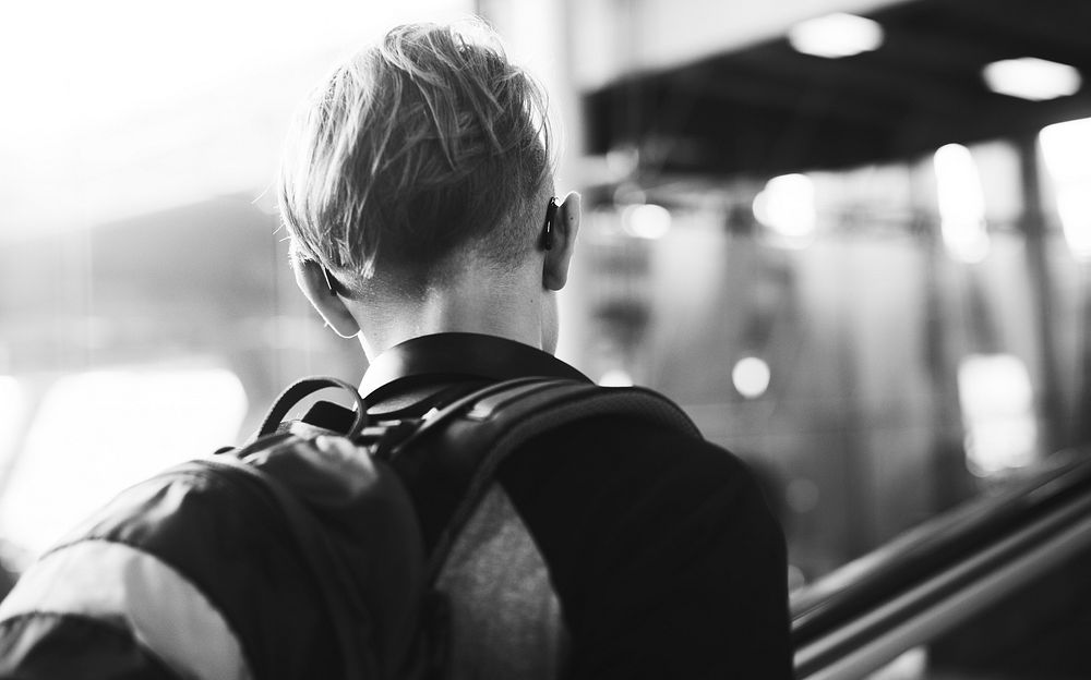 Rear view of young caucasian man at airport grayscale