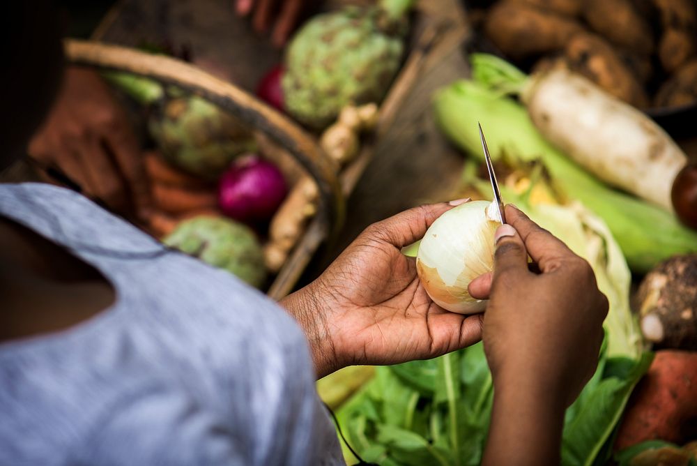African ethnicity woman peeling a onion