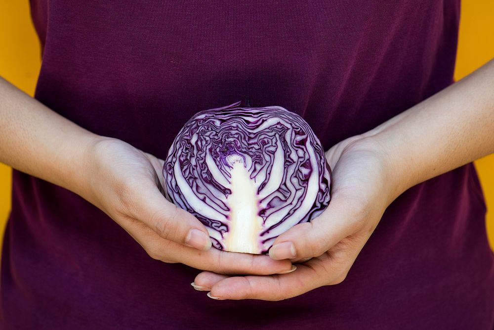 Woman with violet holding purple cabbage in the hands