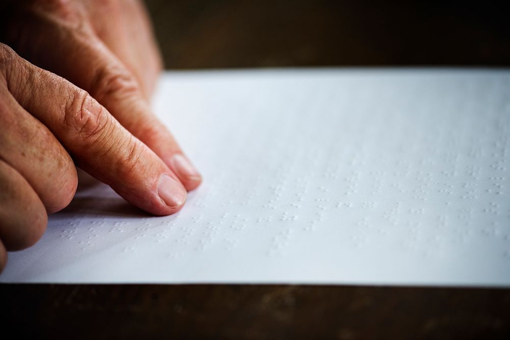Closeup of hands touching reading braille letters