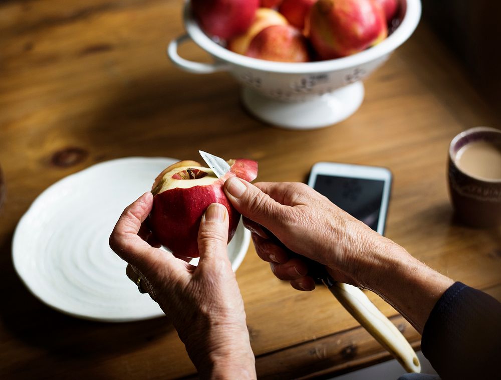 Closeup of hand with knife peeling apple