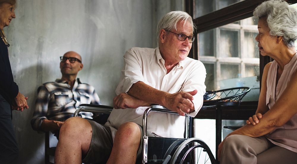Senior man on a wheelchair talking with his friend