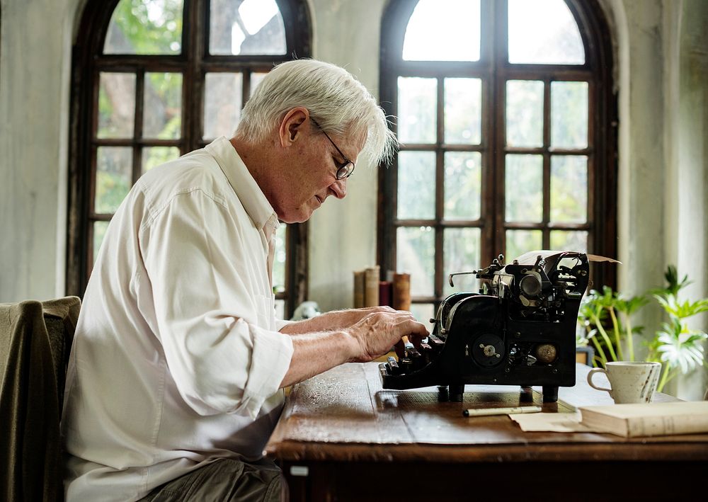 Senior man using typewriter