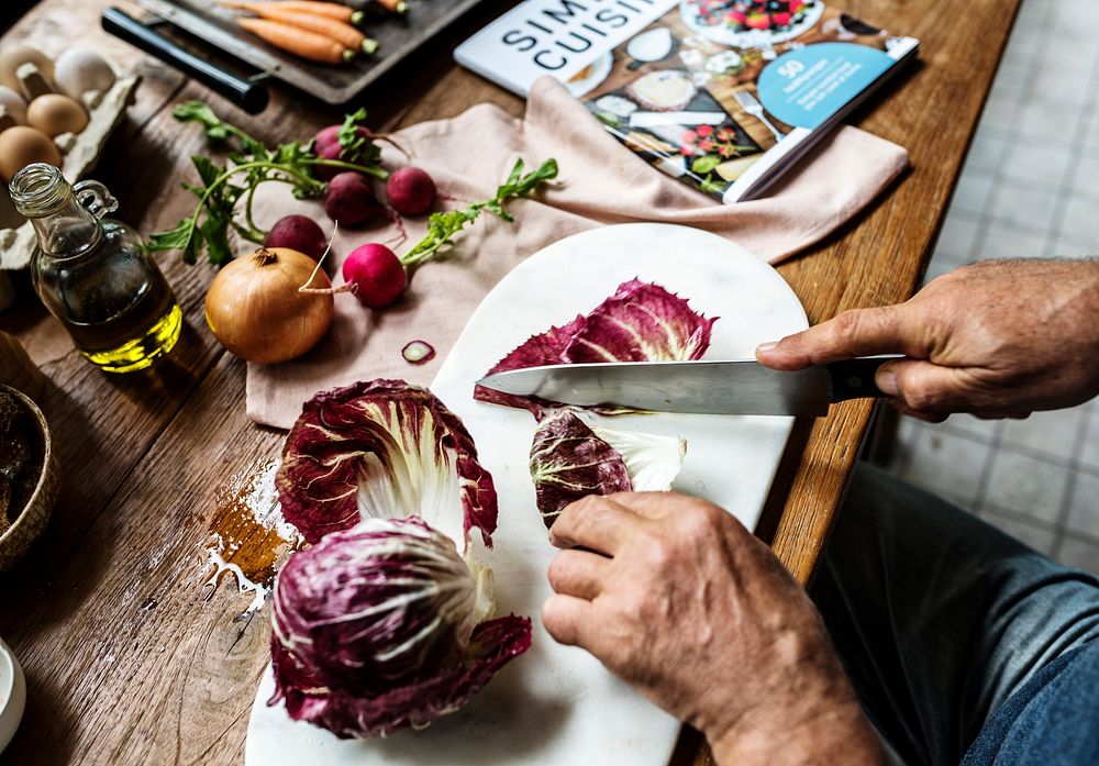 Hands using knife cutting a cabbage
