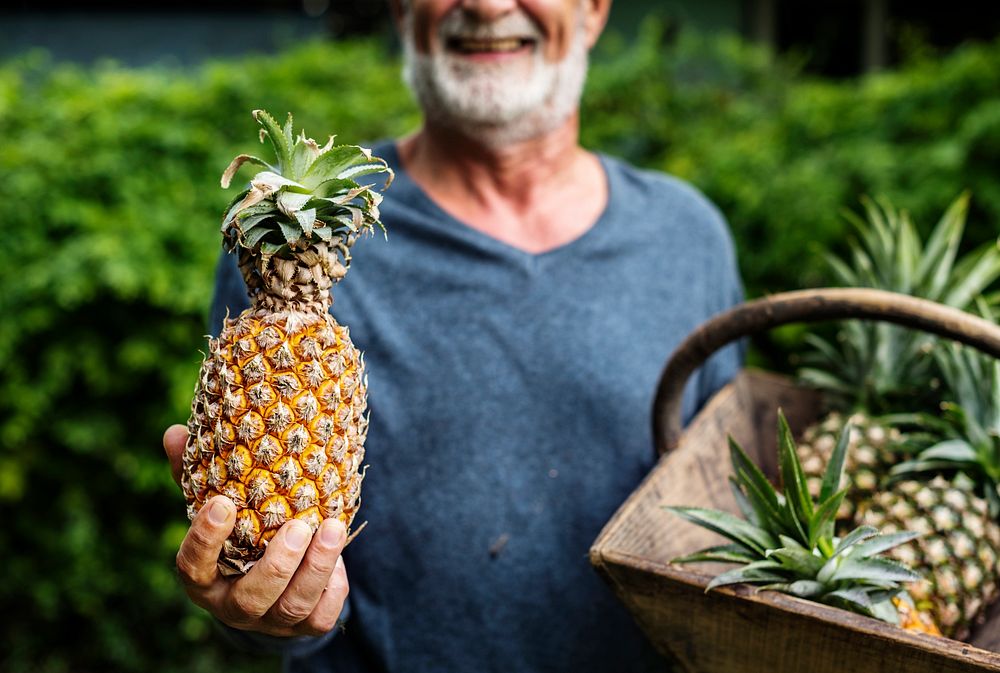Man holding pineapple in the basket