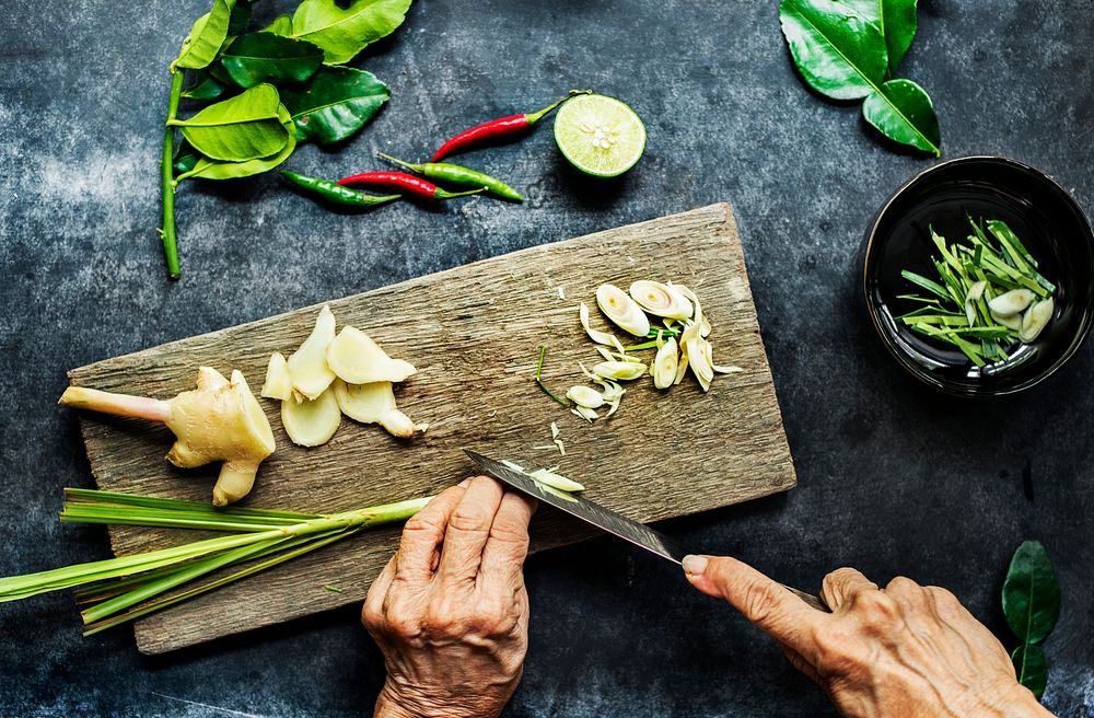 Aerial view of hands with knife cutting lemon grass
