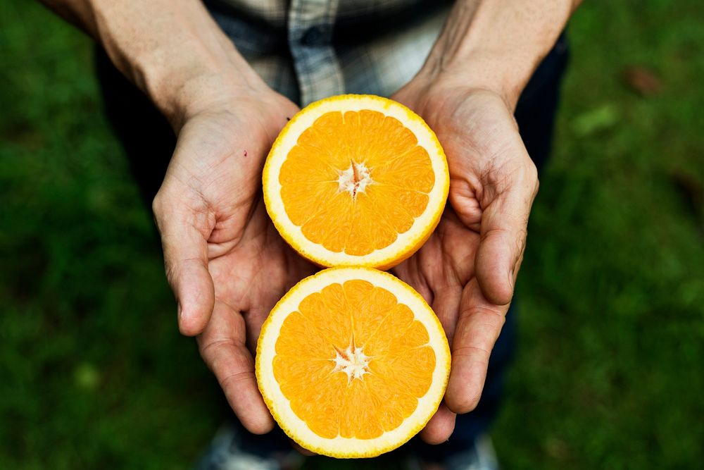 Hands holding a fresh cut orange