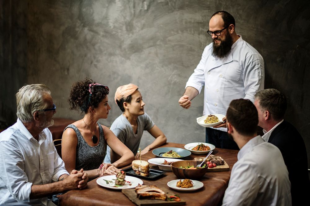 Chef presenting food to customers in the restaurant