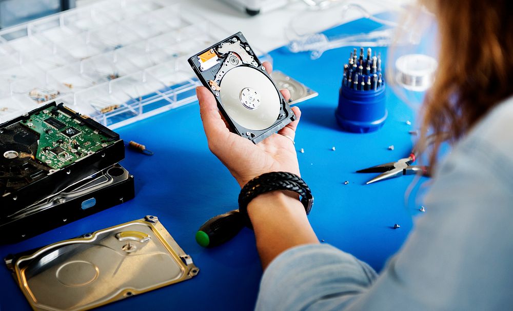 Technician holding HDD fixing at electronic repair shop