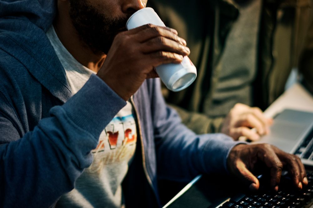 Hacker drinking a can beverage while working